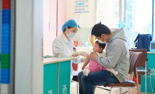 중국에서 한 아기가 아빠의 품에 안겨 독감 예방 접종을 맞고 있다. /글로벌타임스