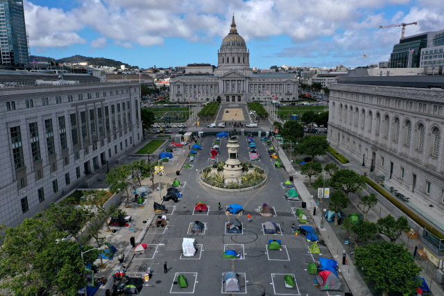 지난 5월 미국 샌프란시스코 시청 앞 광장에 노숙자 텐트가 일정한 간격에 맞춰 설치돼 있다. 미국의 자유 성과주의적 자본주의는 고학력 엘리트에게 자본 소득과 노동 소득을 동시에 안겨주고 있다./AFP연합뉴스