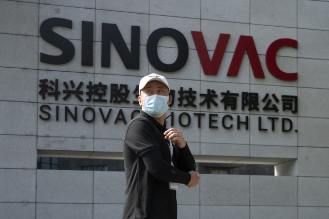 한 중국인이 베이징의 시노백 앞을 지나가고 있다. 시노백은 내년 초까지 백신을 승인받고 양산 체제를 갖춘다는 계획이다. /AP연합뉴스