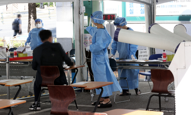 24일 오전 서울 강남구보건소에 마련된 신종 코로나바이러스 감염증(코로나19) 선별진료소에서 의료진이 시민들의 검사를 돕고 있다. /연합뉴스