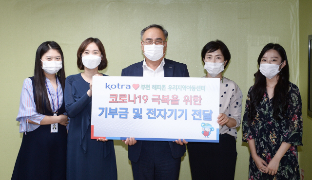 김종춘(가운데) KOTRA 부사장이 지난 25일 부천 ‘해피존 지역아동센터’를 찾아 교육용 전자기기와 기부금을 전달한 뒤 기념촬영을 하고 있다. /사진제공=KOTRA