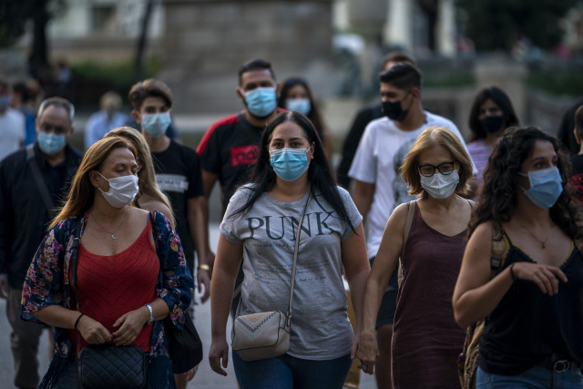 지난 23일(현지시간) 스페인 바르셀로나에서 마스크를 착용한 시민들이 길을 걷고 있다. 유럽을 중심으로 코로나19 재확산세가 가팔라지자 세계 경제 전망이 불투명해지고 있다./AP연합뉴스