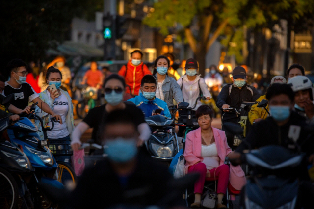 지난 16일 중국 베이징의 한 교차로를 시민들이 지나가고 있다. /AP연합뉴스