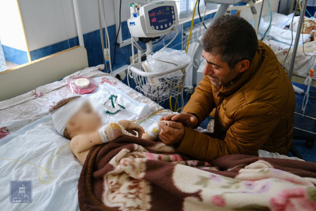 28일 아르메니아의 한 병원에서 한 남성이 아르메니아와 아제르바이잔의 교전 과정에서 다친 것으로 추정되는 아이의 손을 잡고 있다. /로이터연합뉴스