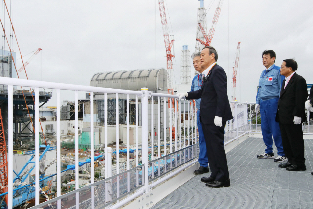 스가 요시히데 일본 총리가 지난 26일 후쿠시마 제1원전을 방문해 책임자 설명을 듣고 있다. /AFP연합뉴스