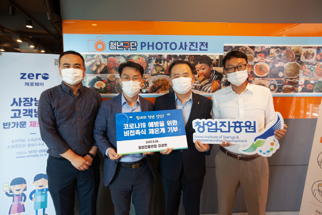 김광현(오른쪽 두번째) 창진원장이 지난달 28일 청년상인육성재단에 체온계를 기부했다는 뜻의 손팻말을 들고 포즈를 취하고 있다./사진제공=창진원