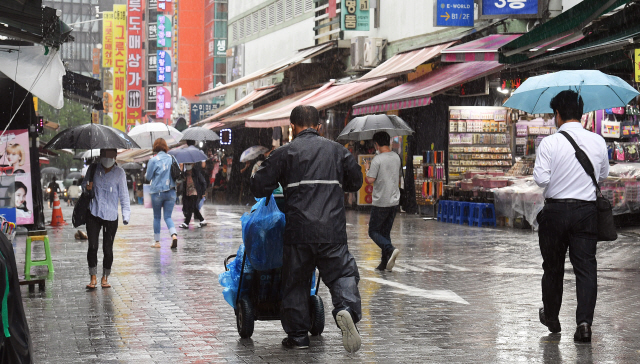 지난 7일 서울 중구 남대문시장에서 한 상인이 비바람을 맞으며 물건을 옮기고 있다./오승현기자 2020.09.07