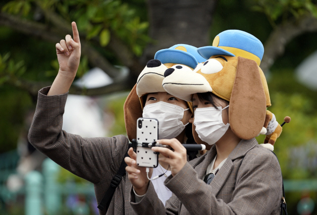 지난달 28일 일본 우라야수의 도쿄디즈니랜드를 찾은 이들이 마스크를 쓴 채 사진을 찍고 있다. /EPA연합뉴스
