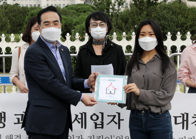 박홍근 더불어민주당 의원이 지난달 23일 오전 서울 여의도 국회 앞에서 열린 임대차3법 후속 과제 해결 촉구 및 ‘세입자 지킴이’ 의원 명패전달 기자회견에서 명패를 받고 있다./연합뉴스