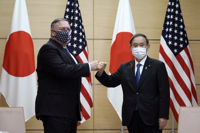 6일 쿼드(미국·일본·호주·인도의 비공식 안보회의체) 회의차 일본을 방문한 마이크 폼페이오(왼쪽) 미국 국무장관이 도쿄 총리관저에서 스가 요시히데 일본 총리와 주먹인사를 하고 있다. 지난해에 이어 두번째로 열리는 이번 회의에서 4개국 외교장관은 중국 견제를 위한 안보협력 방안을 논의했다./AP연합뉴스