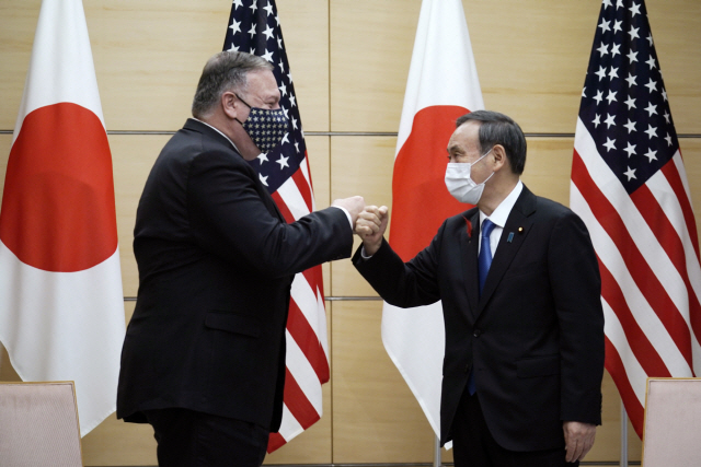 6일 쿼드(미국·일본·호주·인도의 비공식 안보회의체) 회의차 일본을 방문한 마이크 폼페이오(왼쪽) 미국 국무장관이 도쿄 총리관저에서 스가 요시히데 일본 총리와 주먹인사를 하고 있다. 지난해에 이어 두번째로 열리는 이번 회의에서 4개국 외교장관은 중국 견제를 위한 안보협력 방안을 논의했다./AP연합뉴스
