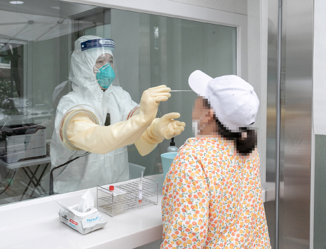 한 시민이 서울 강서구 보건소 내에 마련된 선별진료소에서 신종 코로나바이러스 감염증 검체검사를 받고 있다./사진제공=강서구