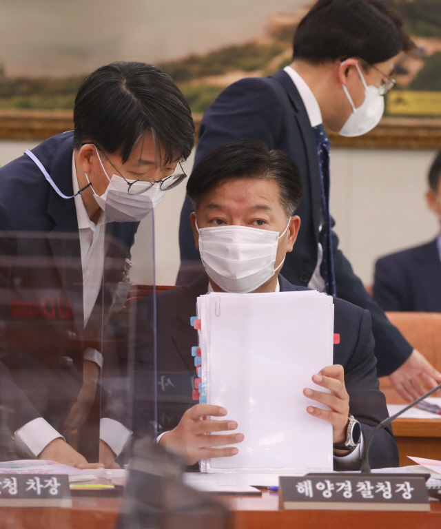 김홍희 해양경찰청장이 8일 오전 서울 여의도 국회에서 열린 농림축산식품해양수산위원회의 해양수산부에 대한 국정감사에서 관계자와 대화를 나누고 있다.