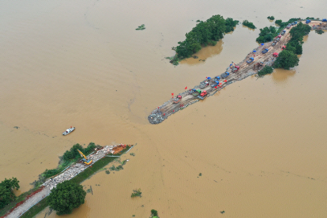 지난 7월 중국 장시성 주장시를 가로지르는 양쯔강 변의 둑이 홍수로 무너져 보수작업이 진행중이다. /AFP연합뉴스