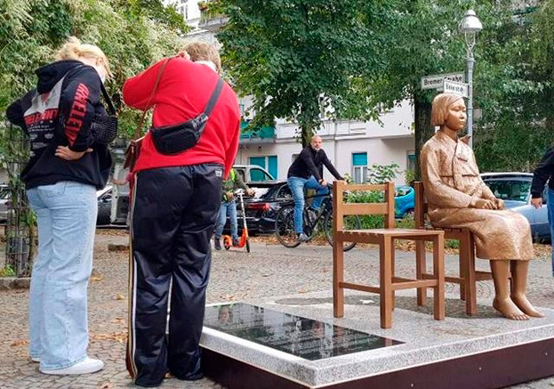 지난달 25일(현지시간) 독일 수도 베를린에 설치된 ‘평화의 소녀상’에 쓰인 비문을 지나가던 시민들이 읽고 있다. /연합뉴스