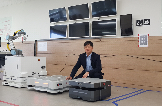김흥수 시스콘 대표가 국내 기술력으로 첫 상용화에 성공한 시스콘의 자율주행 물류로봇(AMR)과 함께 포즈를 취하고 있다.  /사진제공=시스콘