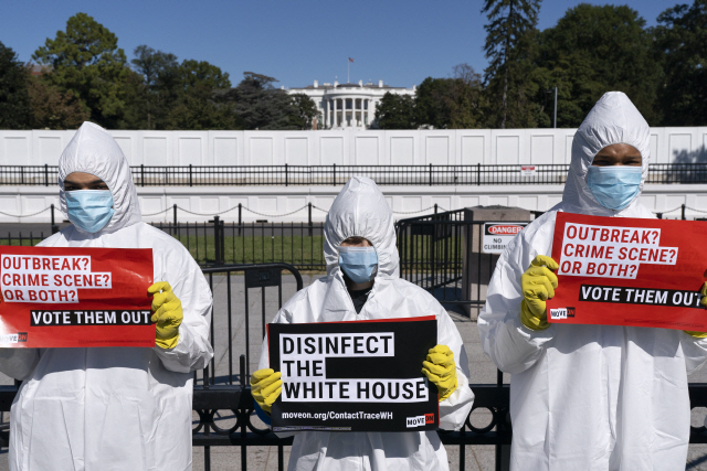 8일(현지시간) 방호복과 마스크·장갑을 착용한 이들이 미국 워싱턴DC 백악관 앞에서 코로나19 발병에 항의하는 시위를 벌이고 있다. /AP연합뉴스