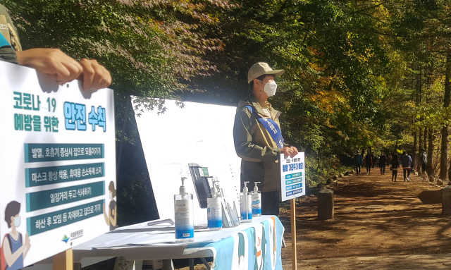 11일 강원 평창군 진부면 오대산 국립공원 탐방로 입구에서 국립공원공단 관계자들이 등산객들에게 사회적 거리두기 준수를 알리고 있다./연합뉴스