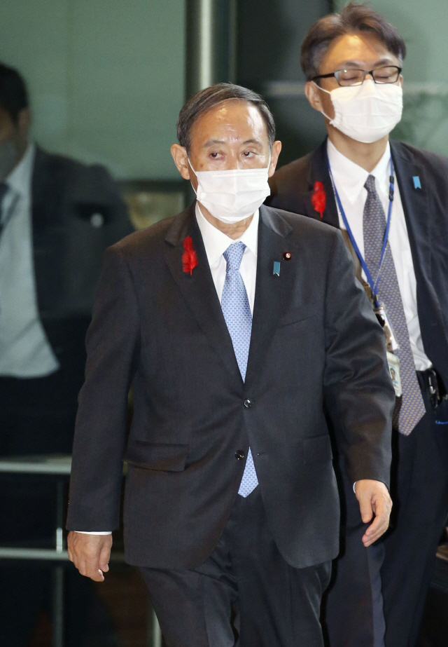 스가 요시히데 일본 총리가 5일 오후 출입 기자단과 공동인터뷰를 마친 뒤 마스크를 쓴 채 관저를 나서고 있다./연합뉴스