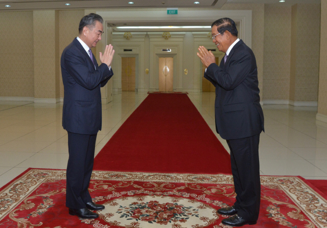 12일(현지시간) 캄보디아를 찾은 왕이(왼쪽) 중국 외교담당 국무위원 겸 외교부장과 훈센 캄보디아 총리가 프놈펜 평화궁전에서 인사를 나누고 있다. 왕 부장은 지난 11일부터 오는 15일까지 캄보디아와 말레이시아·라오스·태국·싱가포르 등 동남아 5개국을 순방한다./AFP연합뉴스