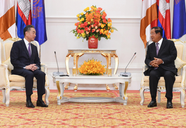 12일(현지시간) 캄보디아를 찾은 왕이(왼쪽) 중국 외교담당 국무위원 겸 외교부장과 훈센 캄보디아 총리가 프놈펜 평화궁전에서 회담을 하고 있다. 왕 부장은 지난 11일부터 오는 15일까지 캄보디아와 말레이시아·라오스·태국·싱가포르 등 동남아 5개국을 순방한다./AFP연합뉴스