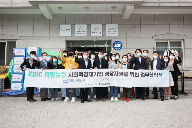 위성백(왼쪽 다섯번째) 예금보험공사장이 김경호(〃 여섯번째) 숲스토리 대표, 나석권(〃 두번째) 사회적가치연구원장 및 임직원들과 함께 13일 경기도 의정부 소재 리사이클 매장인 숲스토리에서 KDIC 희망뉴딜 업무협약을 체결한 뒤 화이팅을 외치고 있다. 예보는 사회적기업을 선정하고 생활용품 기부·판매를 통한 고용유지 지원, 제품 구매 및 판로 지원 등을 제공하고 있다. /사진제공=예금보험공사