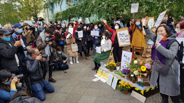 13일(현지시간) 독일 수도 베를린에서 시민들이 거리에 설치된 ‘평화의 소녀상’에 대한 당국의 철거명령에 항의하기 위해 미테구청 앞에서 집회를 하고 있다. /연합뉴스