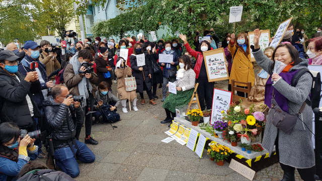 13일(현지시간) 독일 수도 베를린에서 시민들이 거리에 설치된 ‘평화의 소녀상’에 대한 당국의 철거 명령에 항의하기 위해 미테구청 앞에서 집회를 하고 있다. /연합뉴스