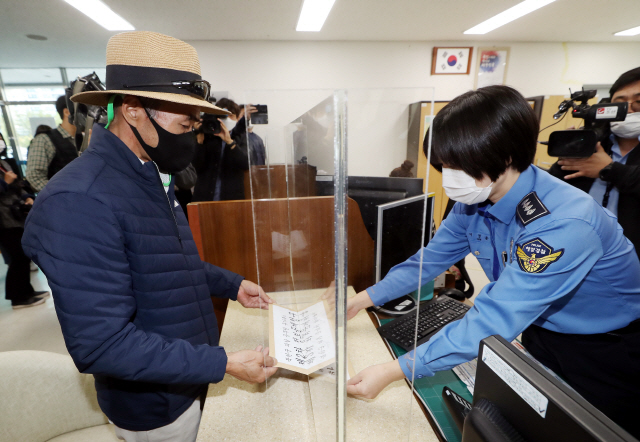 북한군에 사살된 해양수산부 공무원의 형 이래진씨가 14일 오후 인천시 연수구 해양경찰청에서 민원실 관계자에게 정보공개청구 신청서와 항의문을 전달하고 있다. /연합뉴스