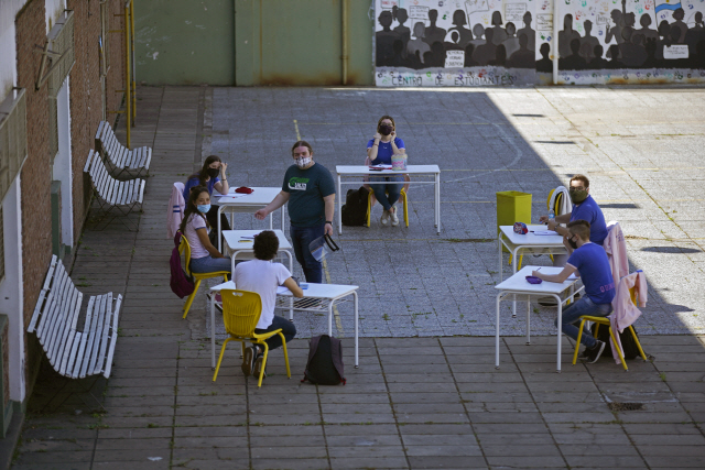 아르헨티나 부에노스아이레스의 한 학교에서 학생들이 건물 밖에 책상을 놓고 수업을 듣고 있다. 부에노스아이레스의 초·중학교 졸업반 학생들은 코로나19 사태 이후 이날 처음 등교했지만 수업은 실외에서 받아야 했다. /AP연합뉴스