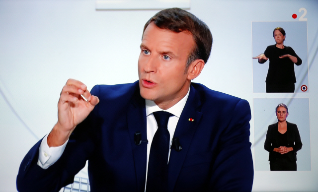14일(현지시간) 에마뉘엘 마크롱 프랑스 대통령이 현지 매체와 인터뷰를 가지고 코로나19 확산세를 막기 위해 일부 지역에 통행금지령을 내린다고 발표하고 있다./EPA연합뉴스