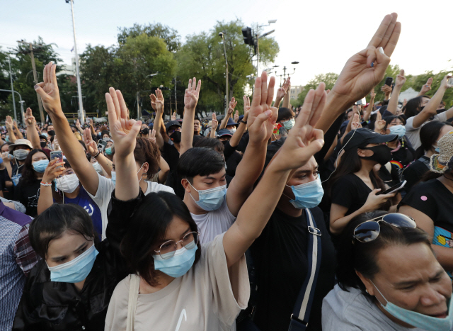 태국 반정부 시위대가 14일(현지시간) 방콕 도심에 모여 세 손가락을 들어올리며 저항의 뜻을 표시하고 있다. 시위대는 총리 퇴진과 군주제 개혁 등을 요구했고 정부는 5인 이상 집회 금지 등 비상조치를 가동했다. /AP연합뉴스