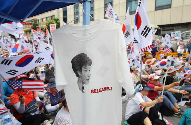 지난해 8월 서울 여의도에서 열린 8차 태극기 집회에서 지지자들이 박근혜 전 대통령 석방을 촉구하는티셔츠를 판매하고 있다. /연합뉴스
