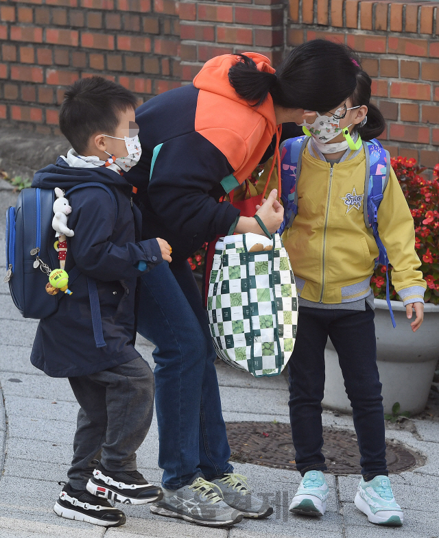 전국 유·초·중·고교의 등교 인원 제한이 학생 3분의 2로 완화되며 초등학교 1학년 매일 등교가 대부분 재개된 19일 오전 서울 서대문구의 한 초등학교에서 한 학생이 배웅나온 엄마와 입을 맞춘 후 등교하고 있다. 교육부는 학력 격차 확대, 돌봄 공백 우려 등으로 등교 확대 요구가 컸던 점을 고려해 과대학교·과밀학급이나 수도권 학교에만 등교 인원 제한 3분의 2를 적용하고, 비수도권 지역 학교 상당수는 자체적으로 정한 기준을 초과하지 않는 한 전교생 매일 등교 방침을 세웠다./오승현기자 2020.10.19