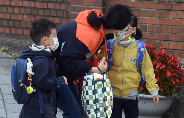 전국 유·초·중·고교의 등교 인원 제한이 학생 3분의 2로 완화되며 초등학교 1학년 매일 등교가 대부분 재개된 19일 오전 서울 서대문구의 한 초등학교에서 한 학생이 배웅나온 엄마와 입을 맞춘 후 등교하고 있다. 교육부는 학력 격차 확대, 돌봄 공백 우려 등으로 등교 확대 요구가 컸던 점을 고려해 과대학교·과밀학급이나 수도권 학교에만 등교 인원 제한 3분의 2를 적용하고, 비수도권 지역 학교 상당수는 자체적으로 정한 기준을 초과하지 않는 한 전교생 매일 등교 방침을 세웠다./오승현기자 2020.10.19