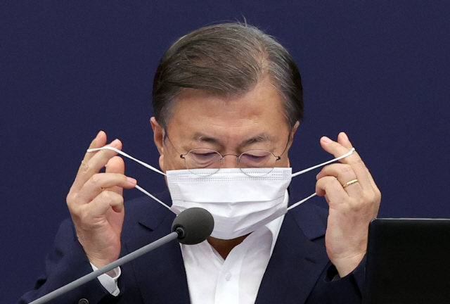 문재인 대통령이 19일 청와대에서 열린 수석·보좌관 회의에서 발언에 앞서 마스크를 벗고 있다./연합뉴스