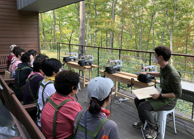 산림치유 프로그램 참가자들이 숲에서 프로그램을 체험하고 있다. 사진제공=한국산림복지진흥원