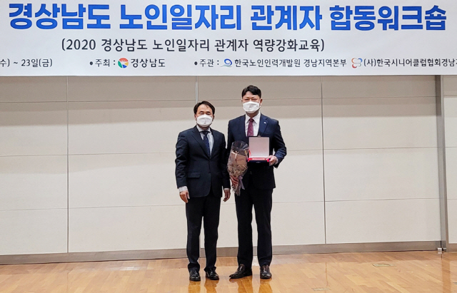 BNK경남은행 김형수(오른쪽) 팀장이 거제소노캄리조트에서 열린 2020년 경남 노인일자리 관계자 합동 워크숍에 참석해 노인복지과 박영규 과장으로부터 도지사 표창을 전달받고 있다./제공=BNK경남은행