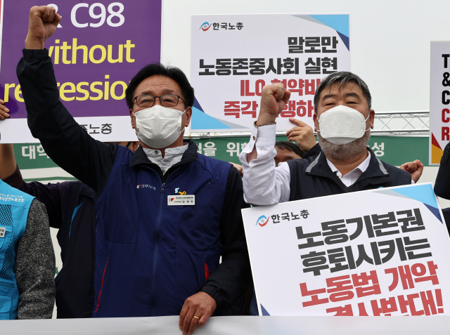 21일 오전 서울 국회 앞에서 열린 ‘정부의 반노동적 노동법 개악반대 및 ILO핵심협약 비준촉구 양대노총 기자회견’에서 김동명(오른쪽) 한국노총 김동명 위원장과 김재하 민주노총 비상대책위원장이 구호를 외치고 있다.  /연합뉴스