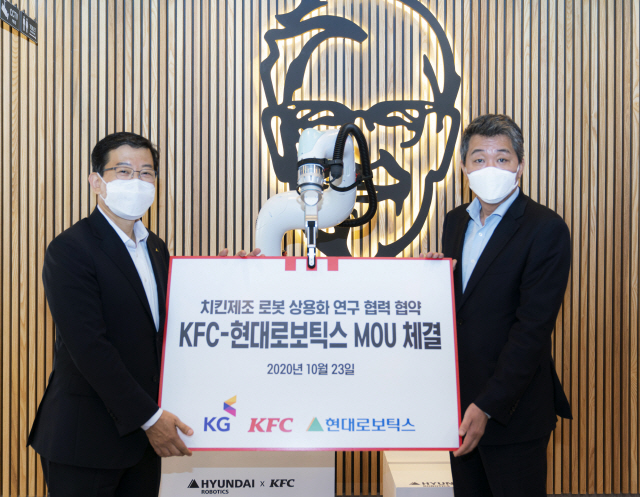 23일 서울 은평구 KFC 응암점에서 서유성(왼쪽) 현대로보틱스 대표와 엄익수 KFC 대표이사가 ‘치킨 제조 자동화 공동개발’ MOU를 맺고 기념촬영을 하고 있다. /사진제공=현대로보틱스