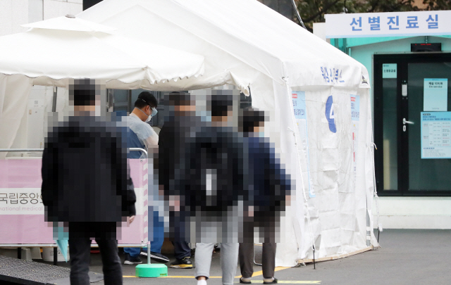 지난 22일 서울 국립중앙의료원 코로나19 선별진료소에서 시민들이 코로나 19 검사를 받기위해 줄을 서 있다. /연합뉴스