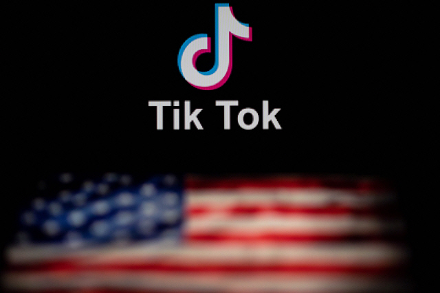 (FILES) In this file photo illustration taken on September 14, 2020 shows the logo of the social network application TikTok (top) and a US flag (bottom) shown on the screens of two laptops in Beijing. - Video snippet sharing sensation TikTok on October 21, 2020 said it is cracking down on hateful content, banning anti-Semitic stereotypes and white nationalism posts. Expanded rules against promoting hateful ideologies at TikTok include barring “misinformation and hurtful stereotypes” about Jewish, Muslim and other communities, the company said in a blog post. (Photo by NICOLAS ASFOURI / AFP)        <저작권자(c) 연합뉴스, 무단 전재-재배포 금지>