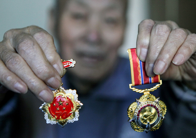 중국 랴오닝성 선양에 거주하는 한 참전군인이 ‘항미원조 70주년’을 맞아 지난 22일 취재진에게 참전기념 메달을 보여주고 있다. /AFP연합뉴스