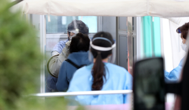 28일 서울 국립중앙의료원 코로나19 선별진료소에서 한 시민이 검사를 받고 있다.  /연합뉴스