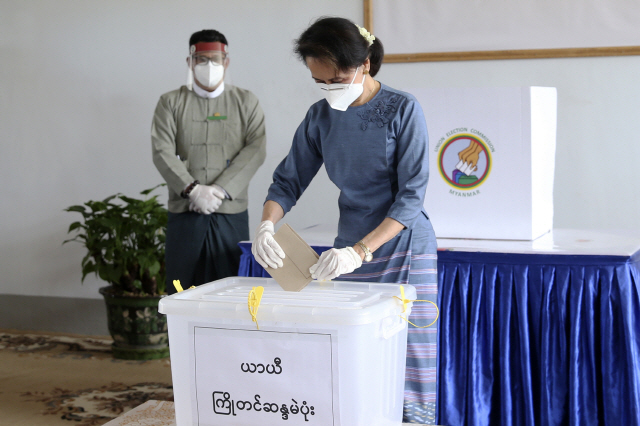다음달 8일 미얀마 총선을 앞두고 아웅산 수지 국가고문이 29일(현지시간) 수도 네피도에 위치한 선거관리위원회 사무소에서 사전투표를 한 뒤 투표용지를 투표함에 넣고 있다. 민주화 이후 처음 치르는 이번 총선을 놓고 공정성과 투명성이 부족하다는 비판이 나오고 있다. /AP연합뉴스