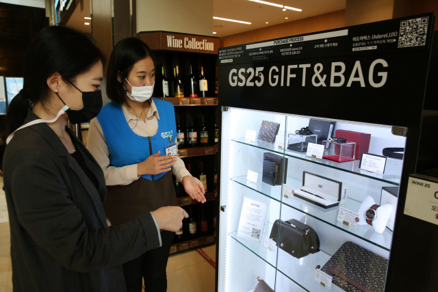 GS25 파르나스타워점 직원이 고객에게 명품 판매대에서 제품 설명을 하고 있다./사진제공=GS25