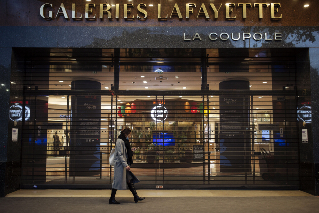 30일 프랑스가 전국 재봉쇄에 들어간 가운데 한 시민이 파리의 문 닫은 상점 앞을 지나가고 있다. /AP연합뉴스
