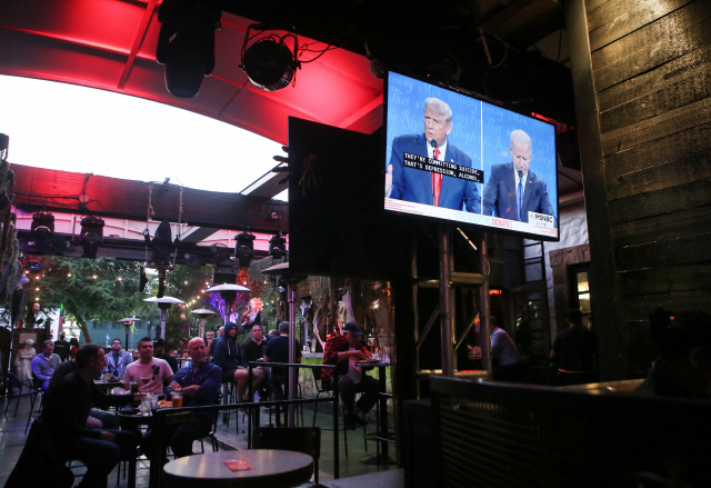 미국 대선 후보 간 마지막 TV토론이 진행된 지난달 22일(현지시간) 캘리포니아의 한 술집에서 사람들이 토론 방송을 시청하고 있다./AFP연합뉴스