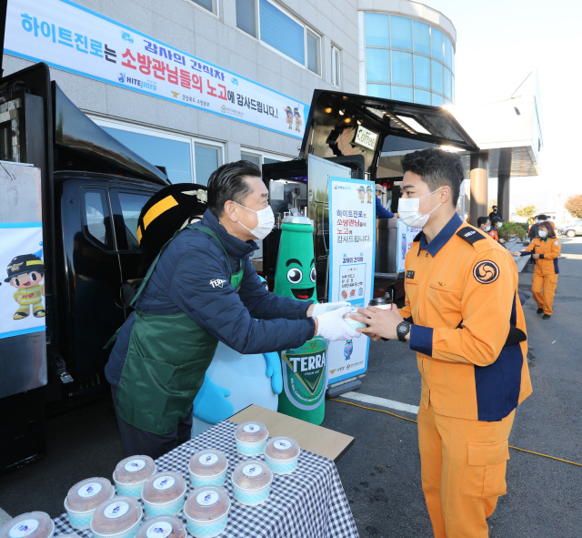 김인규(왼쪽) 하이트진로 사장이 3일 경주소방서에서 진행된 ‘감사의 간식차’ 행사에 참석해 소방대원들에게 간식을 나눠주고 있다. 하이트진로는 지난달 13일부터 이날까지 4주간 전국 20개 소방서를 돌며 소방대원에게 간식을 제공했다. /사진제공=하이트진로