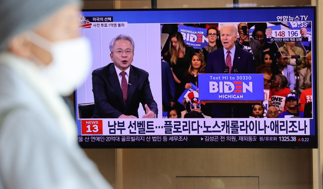14일 오후 서울역에서 시민들이 11·3 미국 대선 개표 상황 뉴스를 TV로 시청하고 있다. /연합뉴스